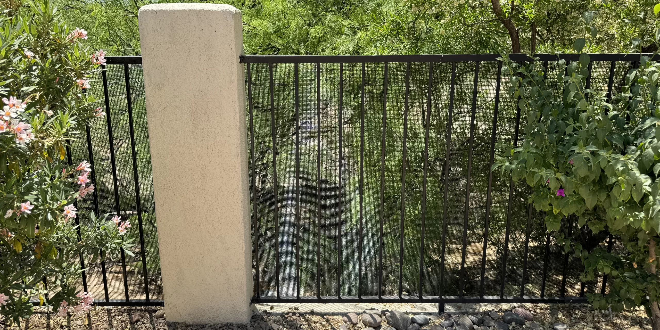 Black mesh barrier installed along an existing residential view fence