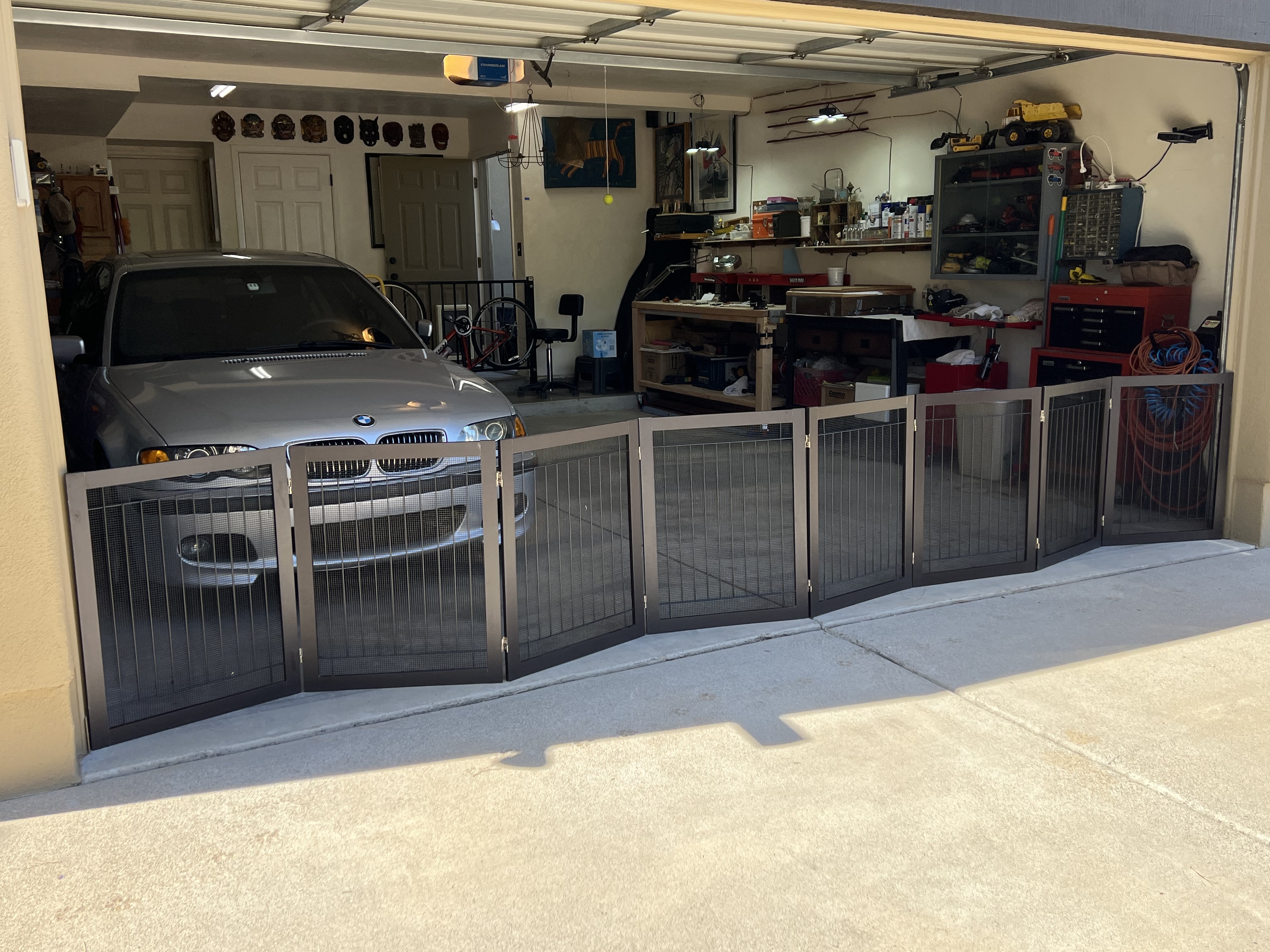 Custom black metal and mesh enclosure panels fitted across an open garage