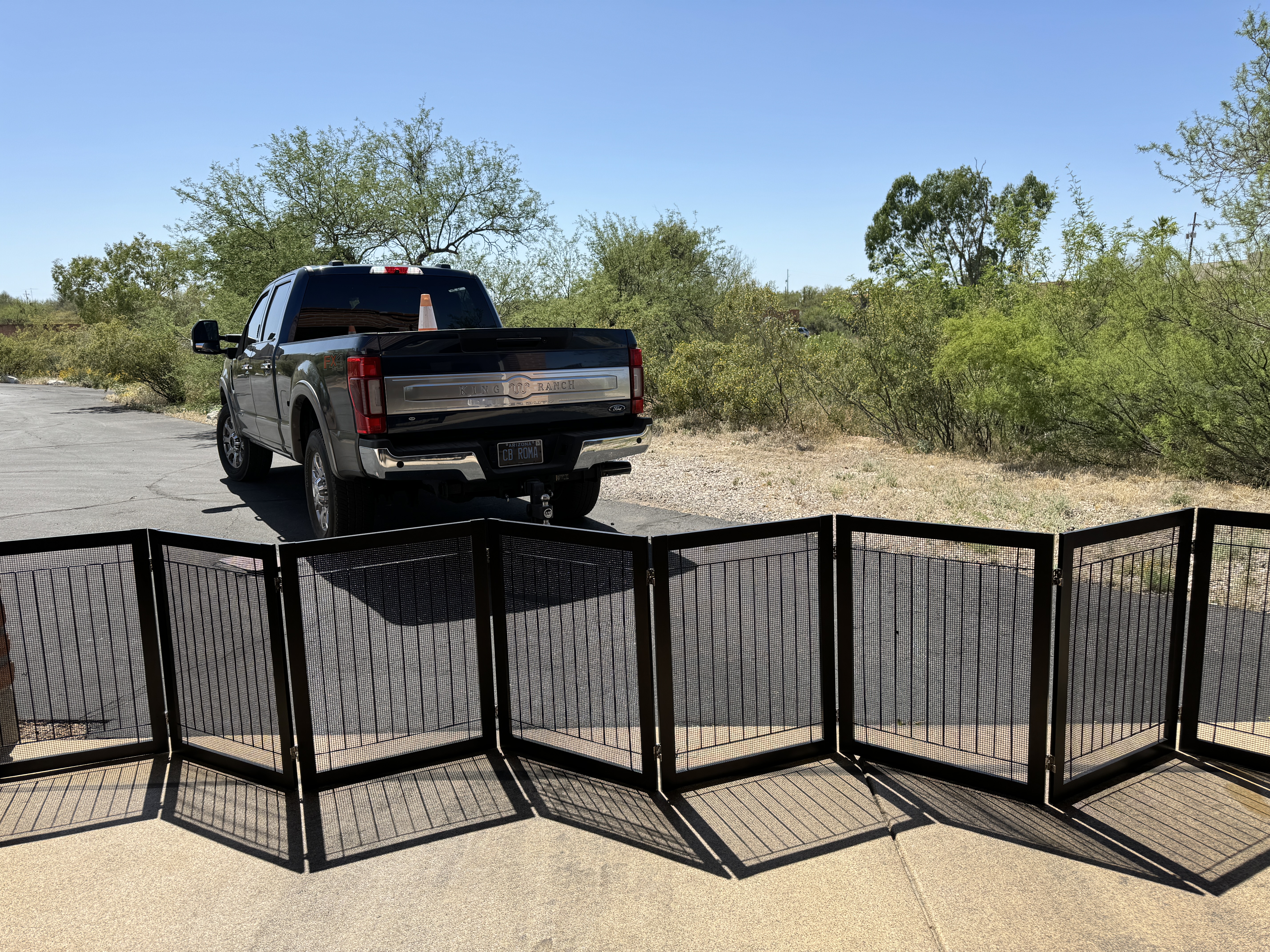 Custom black metal enclosure panels arranged outdoors before installation
