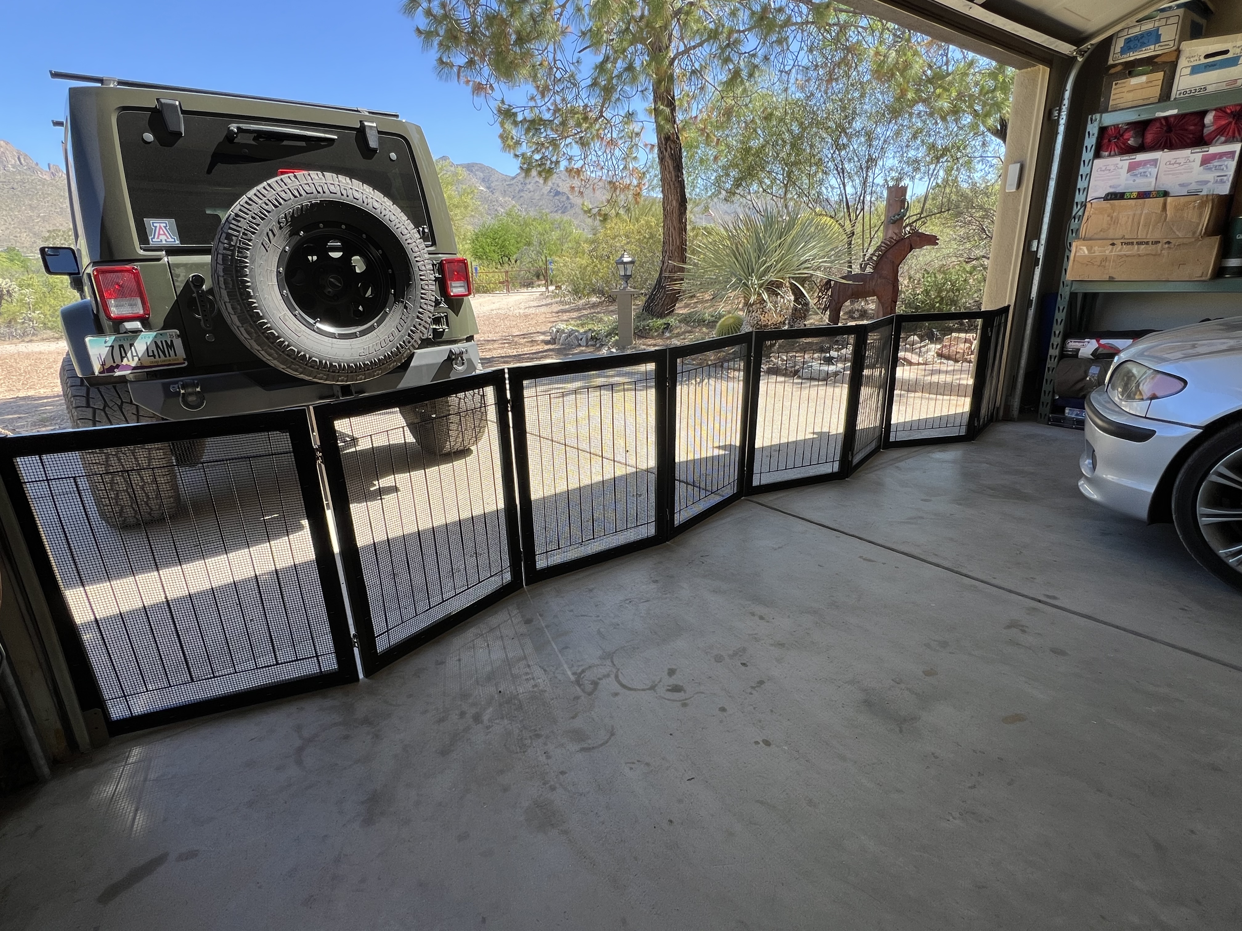 Custom black enclosure panels positioned at a garage opening with a mountain view behind