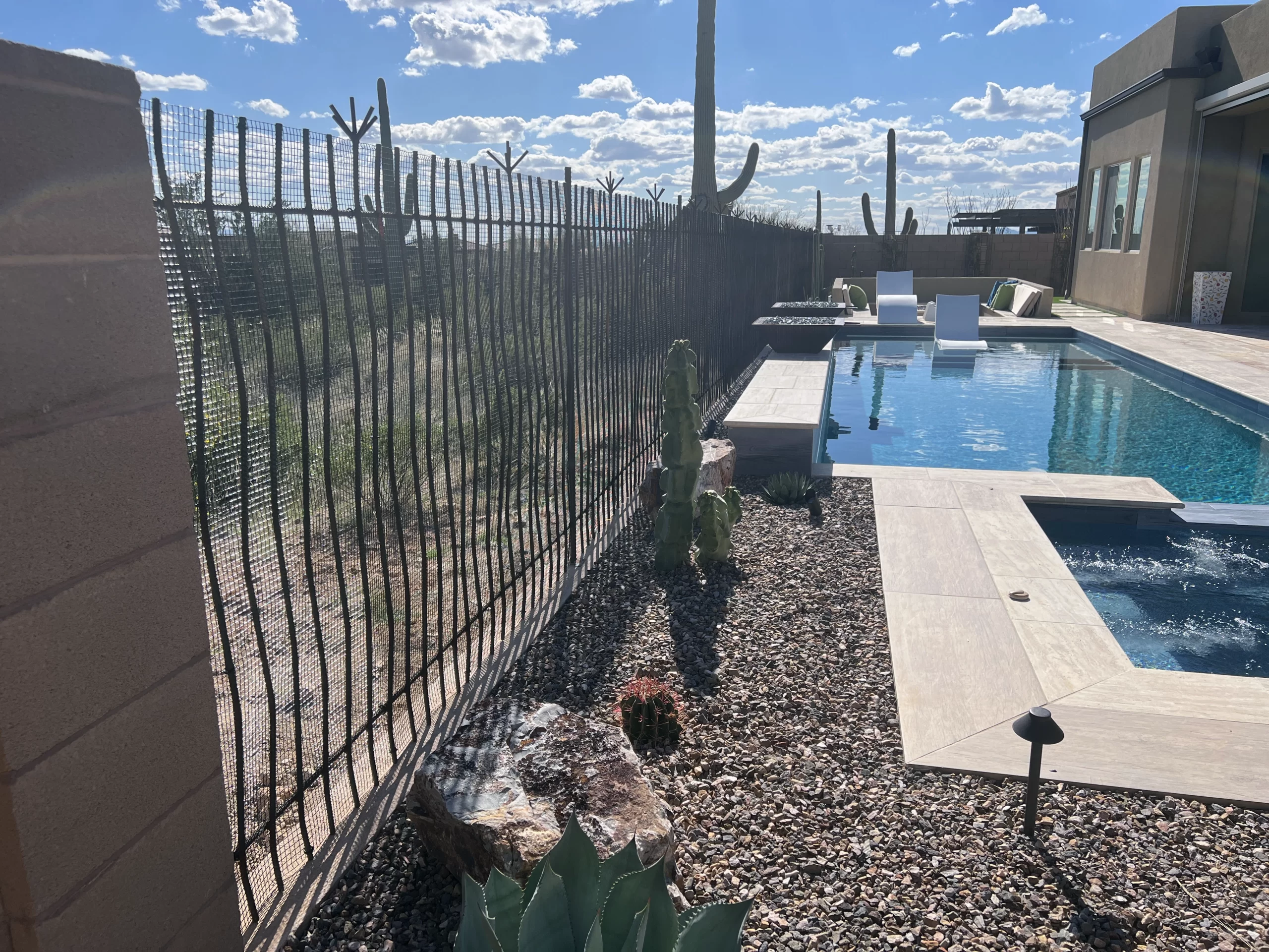 Black mesh barrier installed along view fencing beside a residential pool
